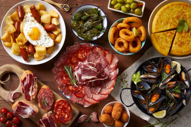 Selección de tapas españolas: bravas, calamares, tortilla, jamón y mejillones